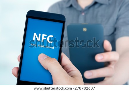 Hand holding smartphone with NFC technology - near field communication data transfer method