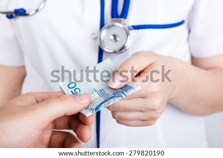 Patient bribing doctor, giving money to the hand