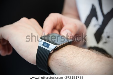 Hand wearing smartwatch connected to smartphone