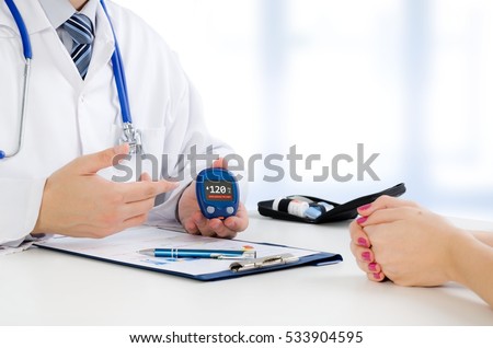 Doctor shows glucometer with glucose level. doctor patient diabetes glucometer blood glucose office hand concept