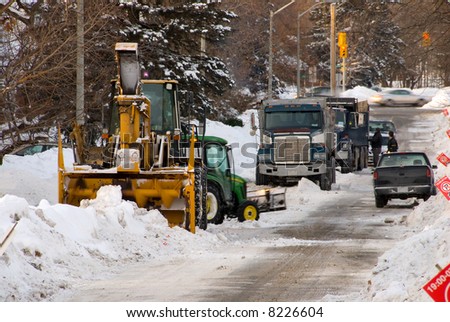 Municipal snow removal crew; giant snow thrower, trucks lined up to cart away the snow, and small plow.