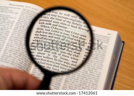 Magnifying glass on a portion from the Hebrew Bible (Deuteronomy).  Selective focus on verse \