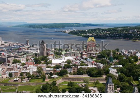 View of old city of Quebec with the St. Lawrence river and Orleans in background and city wall in foreground.  Chateau Frontenac landmark can be seen