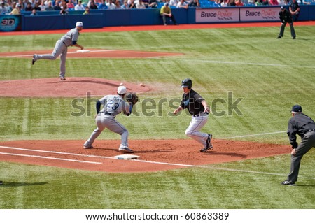 TORONTO - SEPT 11:  Toronto Blue Jays second baseman Aaron Hill runs back to first base as Tampa Bay Rays pitcher Wade Davis throws to first baseman Carlos Pena in Toronto, September 11, 2010.
