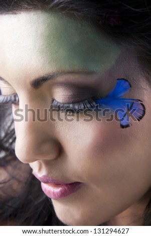 Creative makeup on model with long lashes & feathers