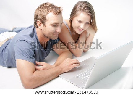 Young couple searching on the laptop searching the internet