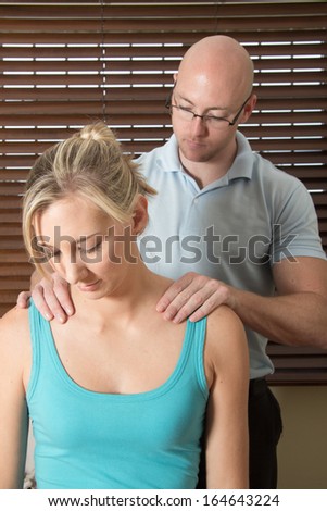 Chiropractor work on the female patient shoulders