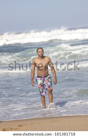 Nice looking African American man walking out of the surf
