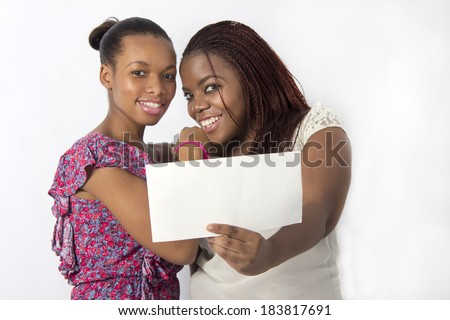 Two best friends laughing and typing on the tablet