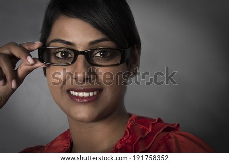 Side profile of woman holding her framed glasses