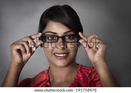 Side profile of woman holding her framed glasses