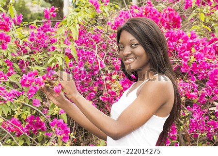 Attractive Young Black woman picking flowers