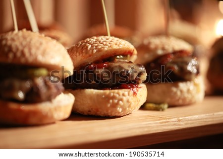 Hamburger sliders  on a rustic cutting wooden board.