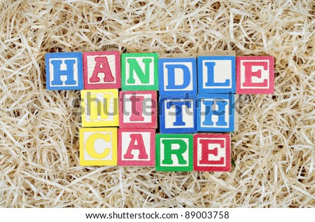 Handle With Care Spelled Out by Blocks in Packing Material