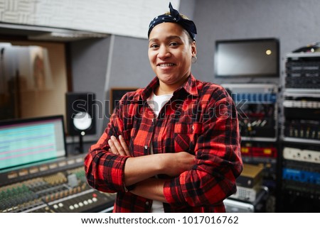 Young worker of audio recording studio looking at camer with her arms crossed by chest