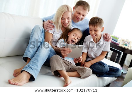Portrait of happy family with two children sitting on sofa