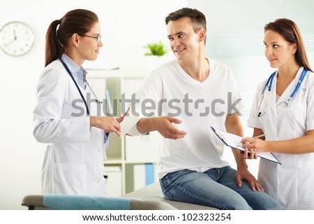 Portrait of confident female doctor giving first aid to patient in hospital