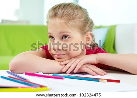 Portrait of lovely girl with colorful pencils near by