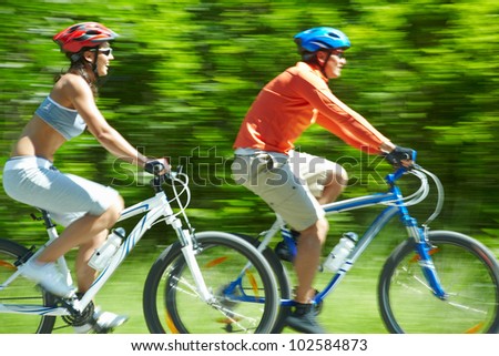 Image in motion of two bicyclists riding on country road