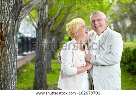 Happy mature woman looking at her husband while having rest outside