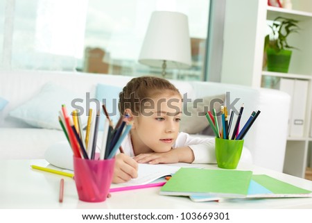 Portrait of lovely girl with colorful pencils near by