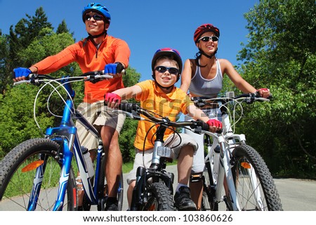 Portrait of happy family on bicycles in the park