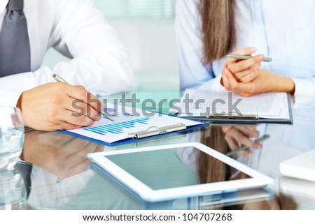 Image of human hands during discussion of business documents at meeting