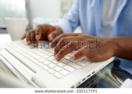 Close-up of African man typing on laptop