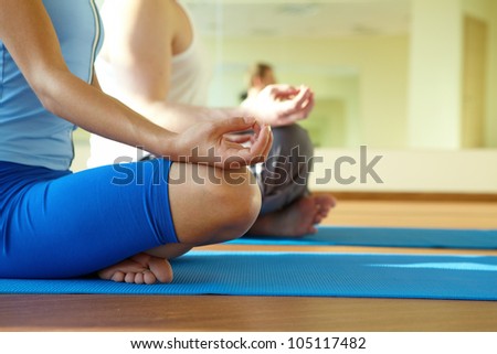 Close-up of feminine and masculine arms and crossed legs during meditation Close-up of feminine and masculine arms and crossed legs during meditation
