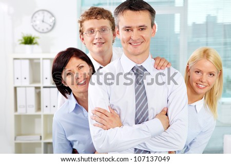 Group of friendly businesspeople with male leader in front