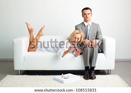 Tensed entrepreneur trying not to pay attention to a sexy female doing her nail nearby