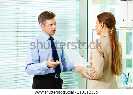 Mature businessman picking a bone with his female co-worker