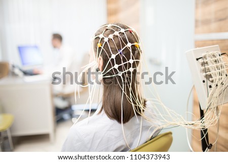 Back view of patient with eeg equipment on her head during brain activity clinical test