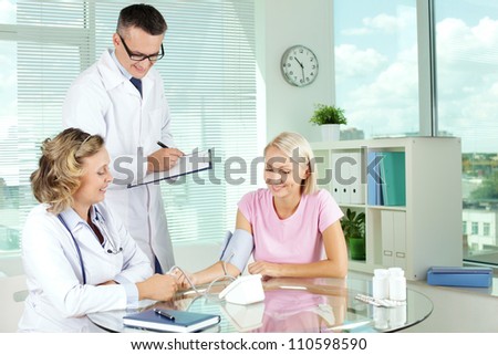 Doctor measuring blood pressure of patient at medical consultation