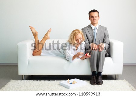 Tensed entrepreneur trying not to pay attention to a sexy female doing her nail nearby