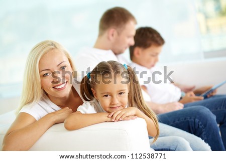 Portrait of happy woman and her daughter on background of father and son