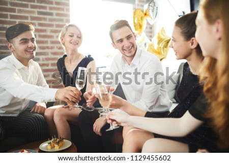 Happy young people with champagne gathered for home party for fun and talk