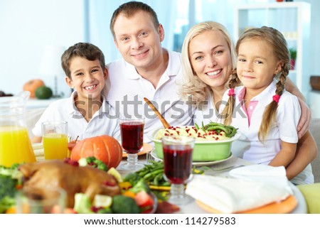 Portrait of happy family sitting at festive table and looking at camera