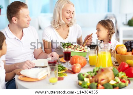 Portrait of happy family sitting at festive table on Thanksgiving Day