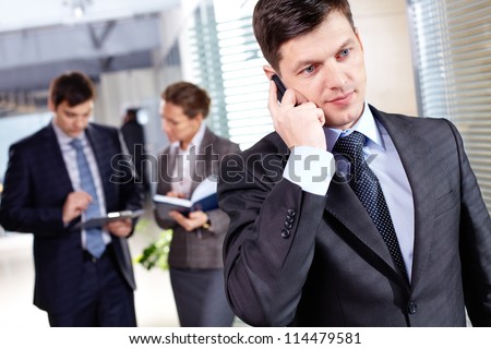 A handsome businessman calling by the phone in working environment