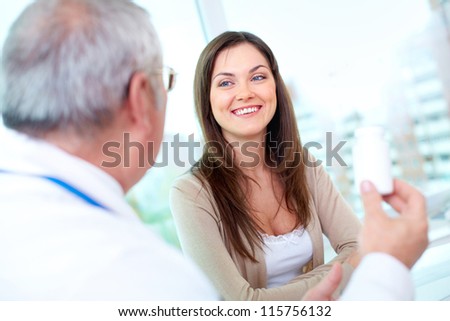 Portrait of pretty patient listening to mature practitioner in hospital