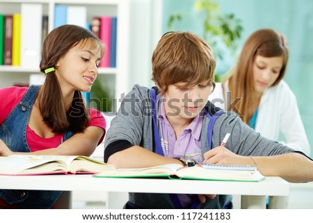 Portrait of smart classmates writing test during lesson