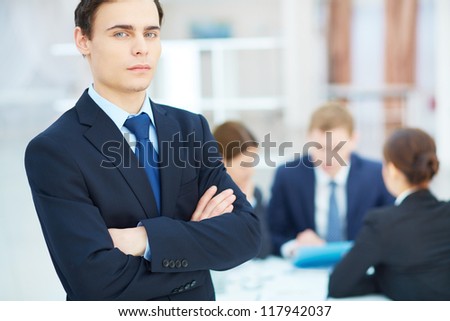 Portrait of young businessman looking at camera in working environment