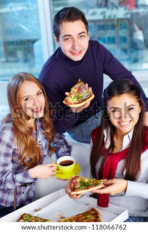 Image of teenage friends eating pizza together