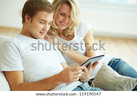 Image of young guy and girl using wireless gadget