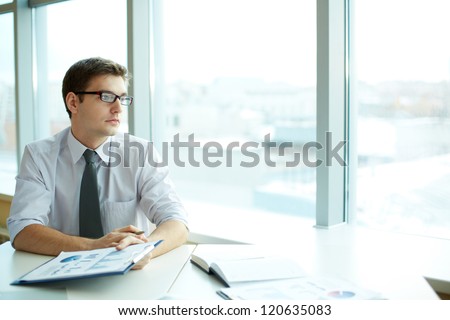 Image of smart businessman with document looking in the office window