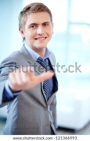 Portrait of cheerful businessman looking at camera while pointing at you