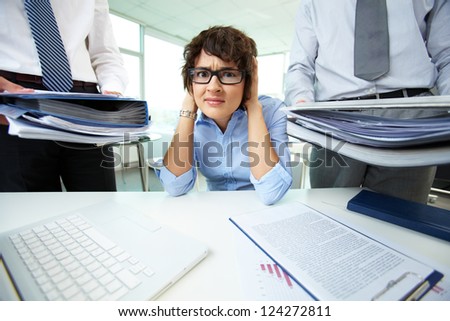 Office lady being scared because of too much paperwork to do