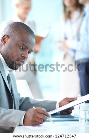 Portrait of busy leader working with papers
