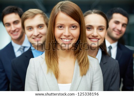 Group of friendly businesspeople with happy female leader in front